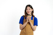 © Phushutter - Cheerful young pretty asian woman blue t-shirt and apron coffee owner isolated on white background. Holding paper coffee cup