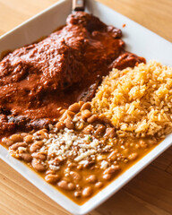 Sticker - Plate of Charro beans and rice with a side of Mole on a wooden surface