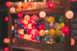 Crowded Christmas market with New Year decorations and multicolored flags, balloons, garlands and festoons, Xmas fair interior, retail sale kiosk and store with illumination