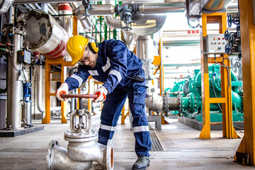 Wall Mural - Hardworking industrial technician inspecting high pressure valve inside refinery plant.