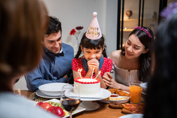 Multi-ethnic big family having a birthday party for young kid daughter. 