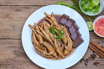 Thai food, chicken feet soup stewed, cooking chicken feet foot stew on white with herbs and spices ingredients with chilli lemon vegetable on wooden background, Asian chinese food menu stew