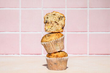 Wall Mural - Chocolate and banana muffins in stack, colorful background, hard light