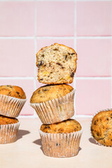 Wall Mural - Close-up of chocolate and banana muffins in stack, colorful background, hard light