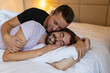 © Graphicroyalty - Gay couple embracing each other with their eyes closed. Two young male lovers touching their faces together while lying in bed in the morning. Affectionate young gay couple bonding at home.