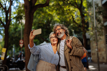 Wall Mural - Senior couple taking selfie outside.