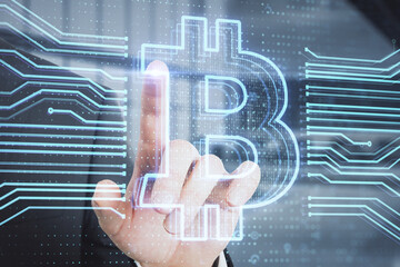 Poster - Close up of businessman hand pointing at creative bitcoin hologram on blurry office interior background. Cryptocurrency and blockchain concept. Double exposure.
