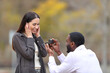 © PheelingsMedia - Marriage proposal of interracial couple in a park