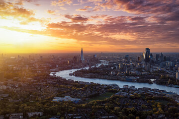 Wall Mural - High panoramic view of the urban skyline of London, England, with the river Thames leading into the City disctrict and beyond during a beautiful sunset