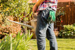 © Westend61 - Close-up of man holding watering can in garden