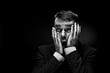 © Westend61 - Mature man gesturing against black background, close up