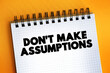 Don't Make Assumptions text on notepad, concept background