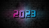 Fototapeta Młodzieżowe - Neon New Year 2023 on grunge brick wall abstract background. Vector greeting card blue purple illumination design