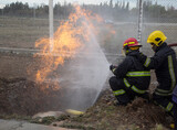 Fototapeta Tęcza - firefighters in full task of putting out the flames of a gas leak