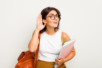 Wall Mural - Young student Indian woman isolated on white background trying to listening a gossip.