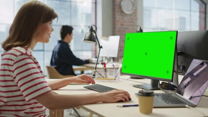 Leinwandbilder - Portrait of White Creative Young Woman Working on a Green Screen Computer in Busy Office. Female Marketing Manager Smiles While Answering Customer Support Emails. Dolly Shot