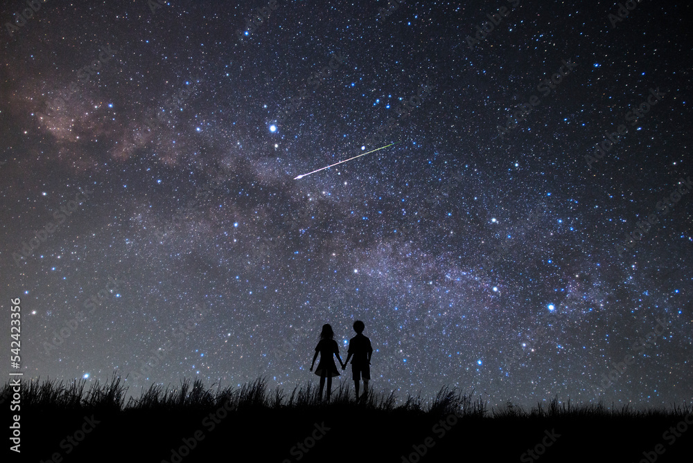天の川と満天の星空を見つめるカップルのシルエット。 Stock Photo