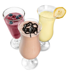 Wall Mural - three glasses of milkshakes, caramelshakes and berryshakes cocktails on a white background