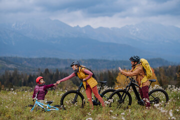 Wall Mural - Young family with little daughter at bicycles, in the middle of autumn nature.Concept of a healthy lifestyle.