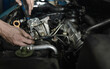 © Cavan Images - Mechanic measuring voltage of car battery