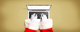 Fototapeta Kawa jest smaczna - Santa Claus using a laptop computer from above