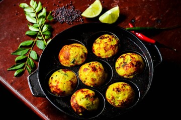 Sticker - Pan with fried dish in designated small areas on a red marble table with spices and lime slices