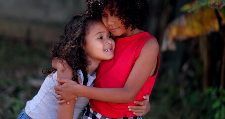 Wall Mural - Children hugging each other. Two little hispanic girls embrace