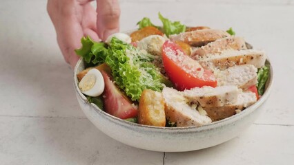 Wall Mural - Hand puts chicken salad in a plate on the table. Tasty appetizer food. 4k video