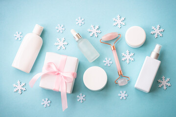 Wall Mural - natural winter cosmetic with holiday decorations and present box on blue background. winter scincare