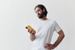 © SHOTPRIME STUDIO - Man blogger holds a phone in his hands and communicates with people online in social networks with a smile and a white t-shirt on a white background