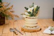 White wedding cake decorated with beautiful arum lilies on a wooden surface, ready to be served