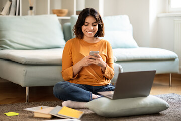 Poster - Happy Young Arab Woman Relaxing At Home With Laptop And Smartphone