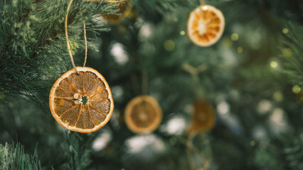 Rustic decorated ornament on Christmas tree with dried orange slices, sustainable Christmas decors concept