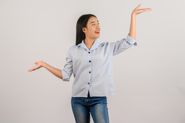 Portrait of young asian woman pointing with two hands and fingers to the side over isolated white background