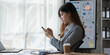 © itchaznong - Beautiful asian businesswoman working with cell phone in office. business finance concept