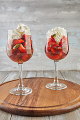 Sticker - Dessert of strawberries and whipped cream in tall glasses on wooden background