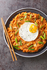 Wall Mural - Kimchi fried rice Bokkeumbap is a type of Korean food closeup on the plate on the table. Vertical top view from above