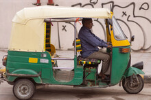 Middle-aged Man Driving Auto Rickshaw On Street