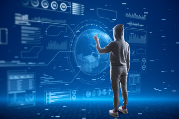 Canvas Print - Hacker in hoodie using abstract glowing digital business interface with globe and various other icons on blurry blue backdrop. Tech, hacking, future and economy concept.