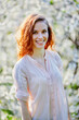 © Sergios - Young beautiful red-haired woman in blooming garden (selective DOF)