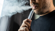 Close-up Mouth Of Man Smoke Inhaling, Breathing And Smoke Electronic Cigarette.