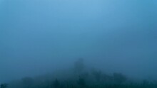 The Timelapse Captures The Mountain Covered In Thick Blanket Of Fog Under Floating Clouds Moving Towards The Himalayan Range, Later The Fog Clearing Up, Revealing The Entire Near And Distant Hills.  