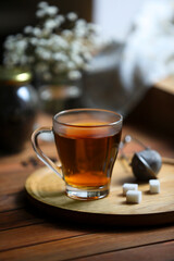 Poster - Tray with cup of freshly brewed tea and sugar cubes on wooden table indoors