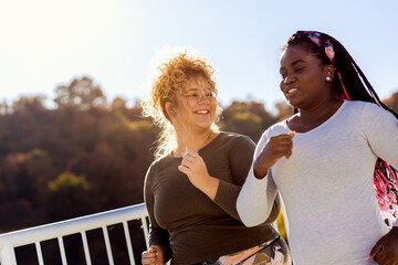 Two young plus size women jogging together.