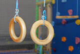 Fototapeta Krajobraz - Gymnastic rings made of wood swing in a children's center