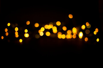 Wall Mural - yellow bokeh in the middle of a black background