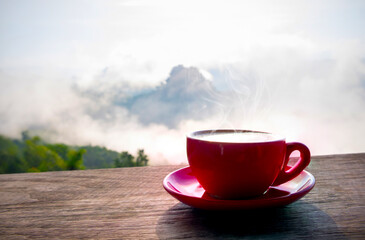 Wall Mural - Hot coffee in red cup with mountain and fog view.