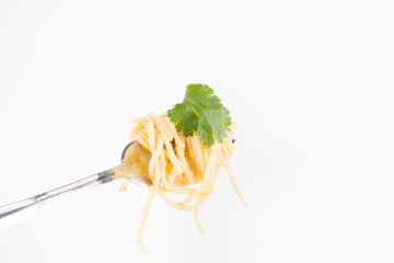 Sticker - Yellow pepper pesto spaghetti covered with grated mozzarella cheese decorated with coriander rolled around a fork