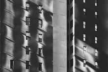 Black And White Abstraction Of Sunlight Reflecting  On Brick Building Façade With Windows In Shadow
