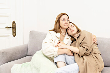 Parents and teens.Mom and teenage daughter are sitting on the couch. Conflict, difficult age. Family.